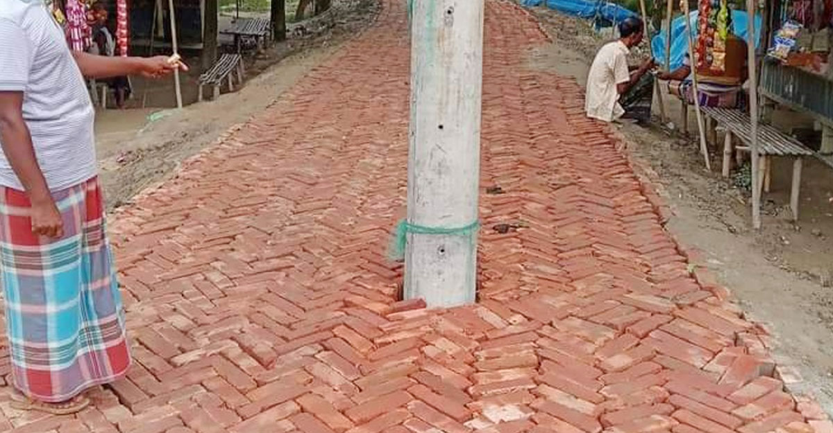 রাস্তার মাঝে বৈদ্যুতিক খুঁটি রেখেই নির্মাণ হচ্ছে সড়ক